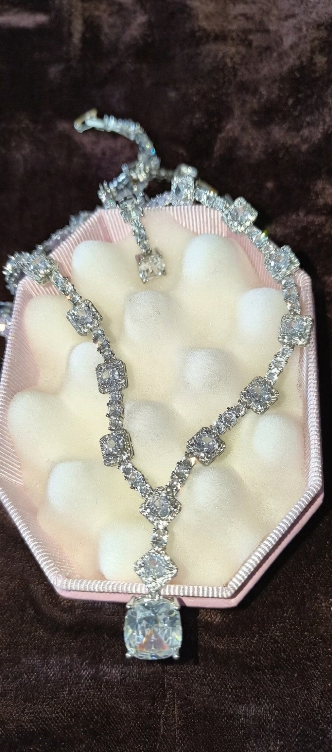 Necklace with a large pendant on a pink stand against a brown background