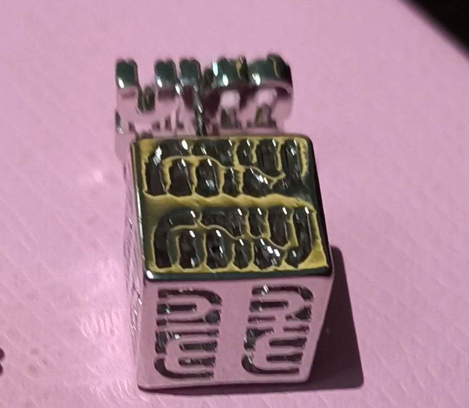 Metallic sewing machine needle bar with engraved text 