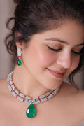 Woman wearing a green emerald necklace and earrings 